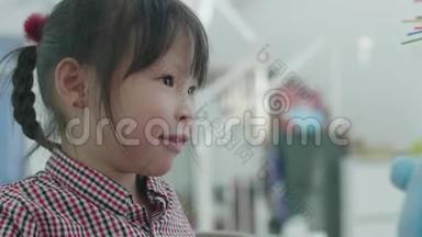 可爱的亚洲小女孩在家和妈妈玩。 一个兴奋的女孩玩一个接一个的玩具玩得开心